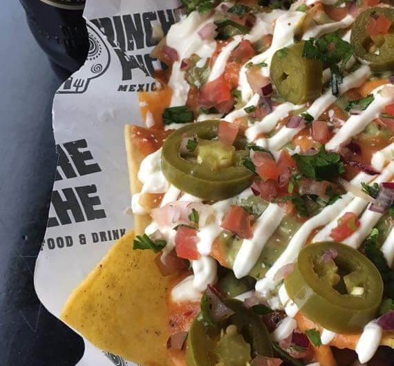 Picture showing nachos made at Pinche Pinche and a bottle of San Miguel